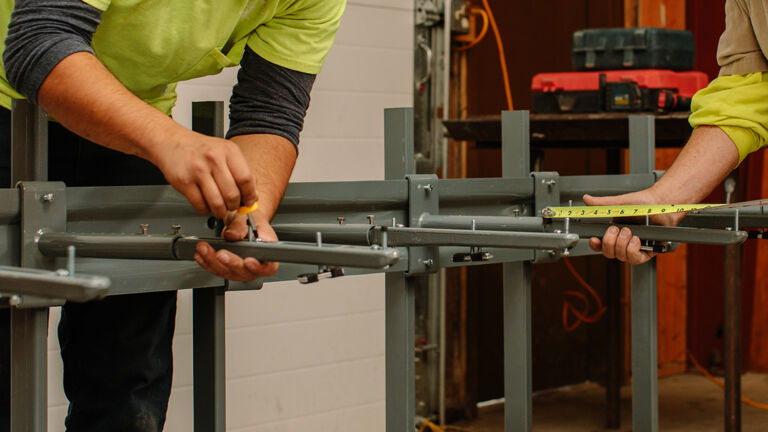 men working on arm installation for lavex machine.